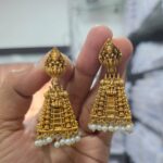 Traditional gold-look jhumka earrings with intricate detailing”